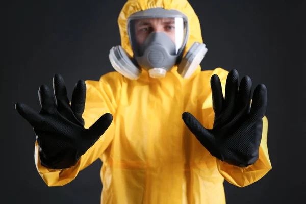 黒の背景に対して停止ジェスチャーを作る化学保護スーツの男は 手に焦点を当てます ウイルス研究 — ストック写真