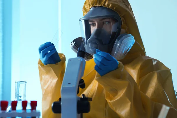 研究室で顕微鏡を使用して化学保護スーツの科学者 ウイルス研究 — ストック写真