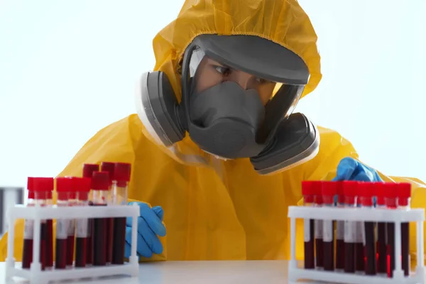 白い背景に血液サンプルを扱う化学保護スーツの科学者 ウイルス研究 — ストック写真