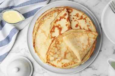 Düz kompozisyon, beyaz mermer masanın üzerinde taze ince krepler vardı.