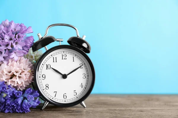 Reloj Despertador Negro Flores Primavera Sobre Fondo Azul Claro Espacio —  Fotos de Stock