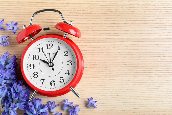Reloj Despertador Rojo Flores Primaverales Espacio Para Texto Sobre Mesa — Foto de Stock
