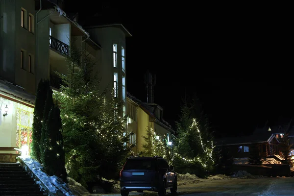 夜にホテルの近くの雪道上の近代的な車 冬休み — ストック写真