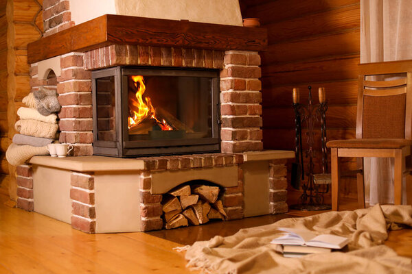 Fireplace with burning wood in room. Winter vacation