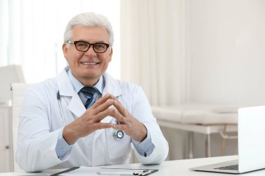 İş yerinde beyaz önlüklü kıdemli doktorun portresi.