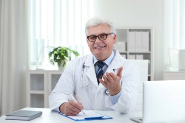 İş yerinde beyaz önlüklü kıdemli doktorun portresi.