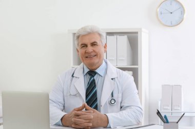 İş yerinde beyaz önlüklü kıdemli doktorun portresi.