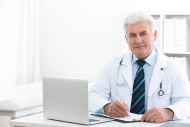 İş yerinde beyaz önlüklü kıdemli doktorun portresi.