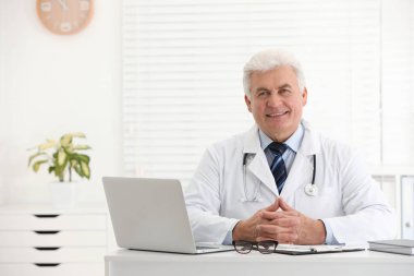 İş yerinde beyaz önlüklü kıdemli doktorun portresi.