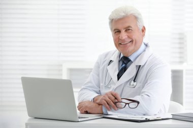 İş yerinde beyaz önlüklü kıdemli doktorun portresi.