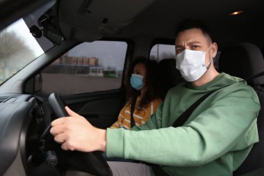 Arabada tek kullanımlık maskeleri olan bir çift. Virüs koruması