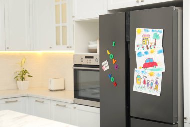 Çocuk resimleri, not ve mıknatıslarla dolu modern buzdolabı. Metin için boşluk