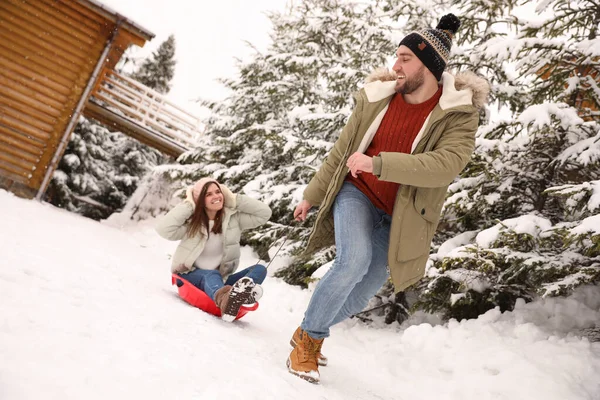 Genç Adam Karlı Bir Günde Kız Arkadaşıyla Kızağını Dışarı Çekiyor — Stok fotoğraf