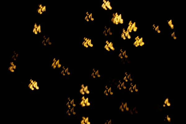 Hämärä Näkymä Nuotin Muotoinen Valot Mustalla Taustalla Bokeh Vaikutus — kuvapankkivalokuva