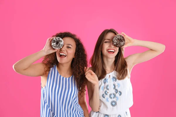 Pembe Arka Planda Donutları Olan Güzel Genç Kadınlar — Stok fotoğraf