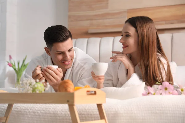 Pareja Feliz Albornoces Desayunando Cama Casa — Foto de Stock