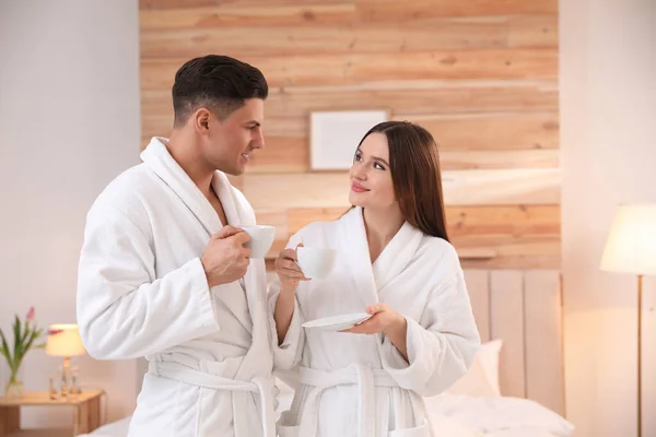 穿着浴衣 在卧室喝咖啡的快乐夫妻 — 图库照片