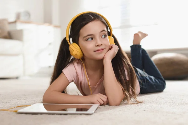 Cute Little Girl Słuchawkami Tabletem Słuchając Audiobook Domu — Zdjęcie stockowe