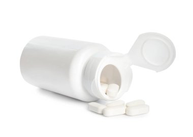 Beyaza izole edilmiş vitamin haplarıyla dolu şişe.