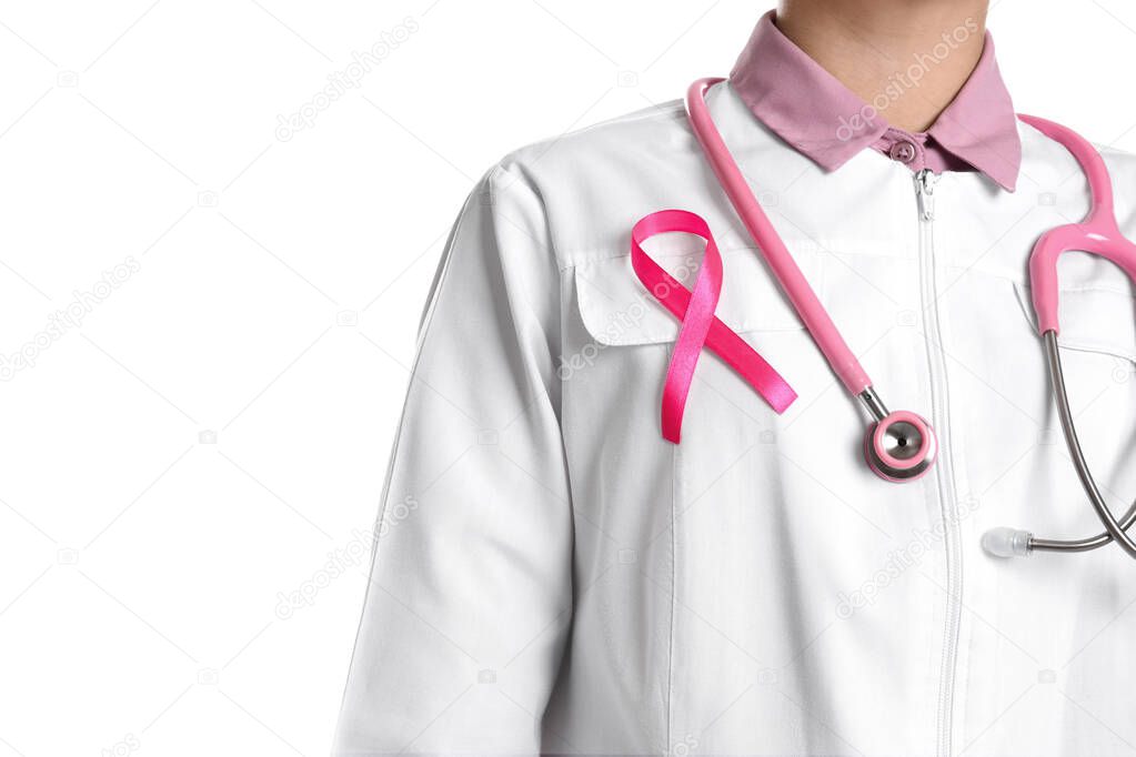Doctor with pink ribbon and stethoscope on white background, closeup. Breast cancer awareness