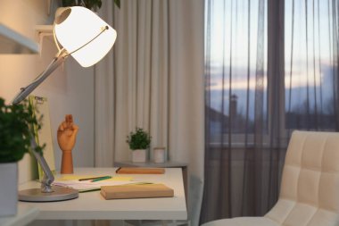 Pencerenin yanında rahat bir iş yeri olan şık bir oda. Tasarım fikri