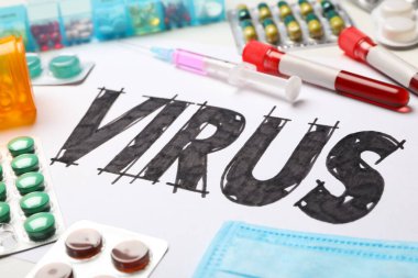 Kelime VIRUS ve ilaçlar beyaz arka planda, yakın plan