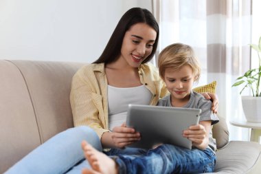 Anne ve oğlu evde E-kitap okuyorlar.