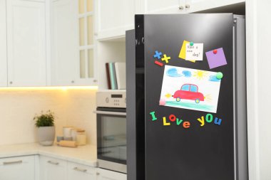 Çocuk resimli modern buzdolabı, notlar ve mıknatıslar mutfakta. Metin için boşluk