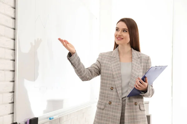 Professional business trainer near whiteboard in office