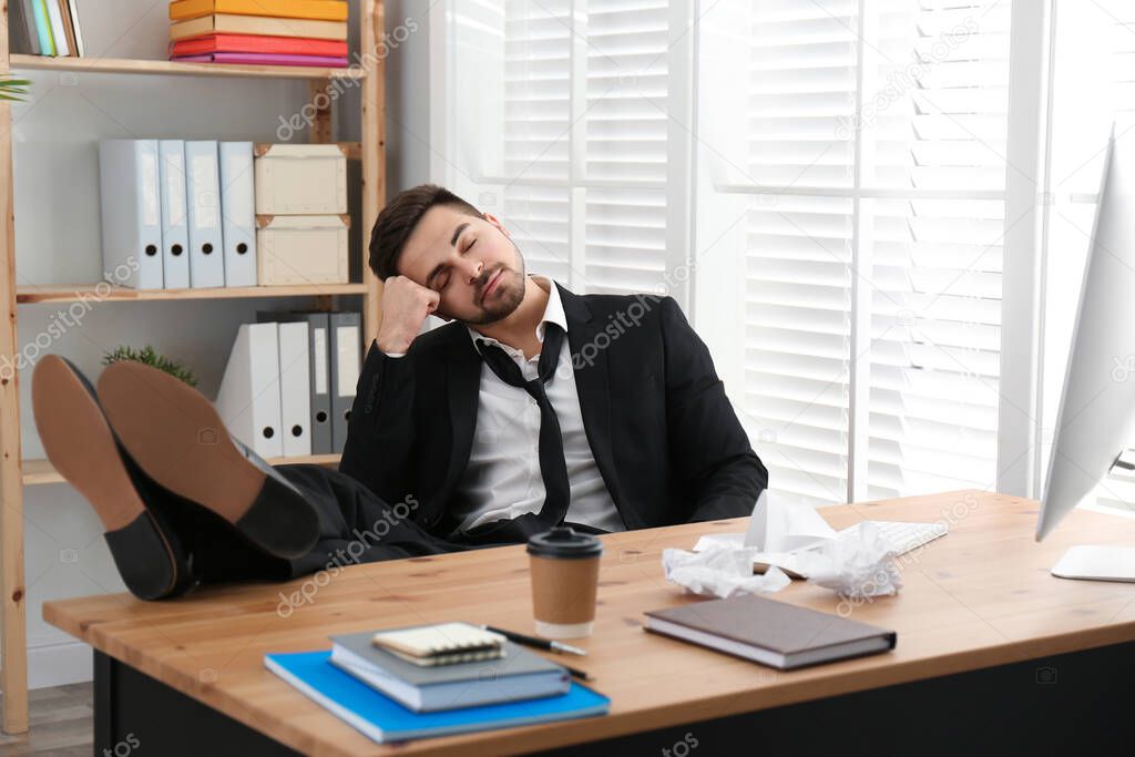 Lazy employee sleeping at table in office