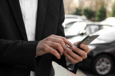 İş adamı şehir caddesinde akıllı telefonlu bir taksi istiyor.