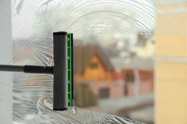 İçeride cam sileceğiyle pencereyi temizliyorum. Metin için boşluk