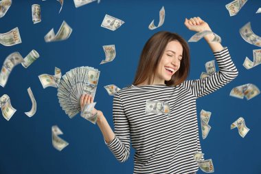 Mavi arka plan üzerinde para yağmur altında dolar ile Mutlu genç kadın