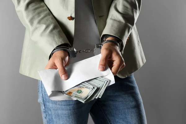 Man Handcuffs Holding Bribe Money Grey Background Closeup — Stock Photo, Image