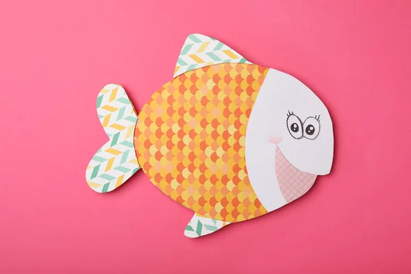 Funny paper fish on pink background, top view. April Fool\'s Day