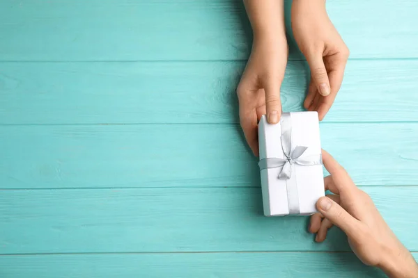 Dochter Geeft Cadeau Aan Haar Vader Aan Lichtblauwe Houten Tafel — Stockfoto