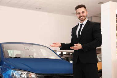 Galerideki yeni arabanın yanındaki genç satıcı.