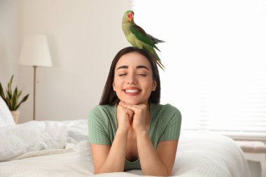 İçeride Alexandrine muhabbet kuşu olan genç bir kadın. Sevimli hayvan.