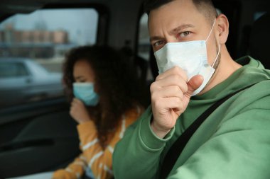 Arabada tek kullanımlık maskeleri olan bir çift. Virüs koruması