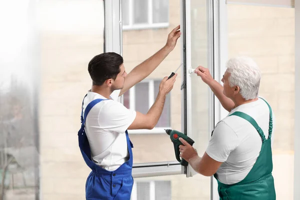 Trabajadores Construcción Reparando Ventana Plástico Con Destornillador Interiores — Foto de Stock