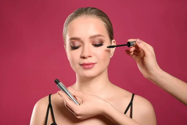 Artista Aplicando Maquiagem Rosto Mulher Fundo Rosa — Fotografia de Stock