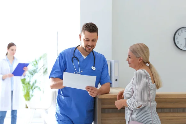 Doctor talking with patient in hospital hall