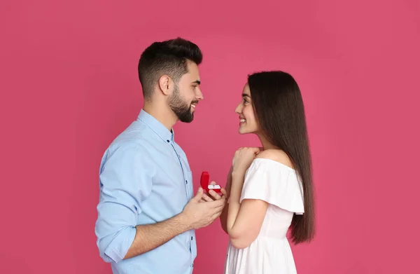 Man Med Förlovningsring Gör Giftermål Med Flickvän Crimson Bakgrund — Stockfoto