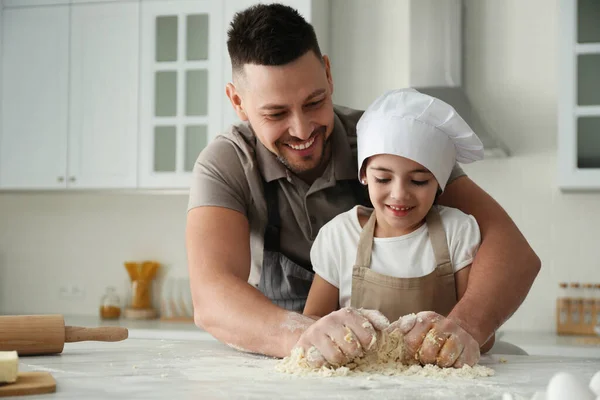 Father and daughter cooking together in kitchen