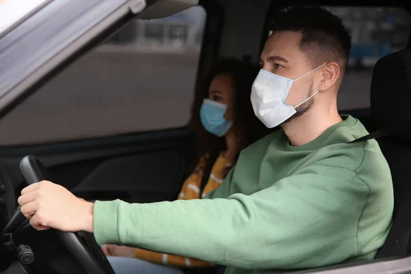 Couple with disposable masks in car. Virus protection