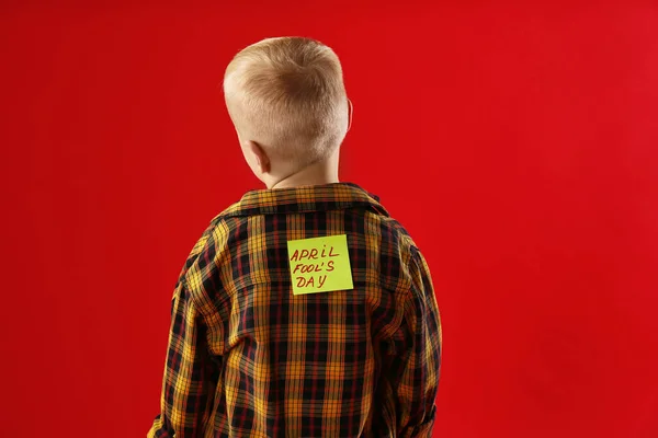 Μικρό Αγόρι Αυτοκόλλητο Πρωταπριλιά Στην Πλάτη Κόκκινο Φόντο — Φωτογραφία Αρχείου