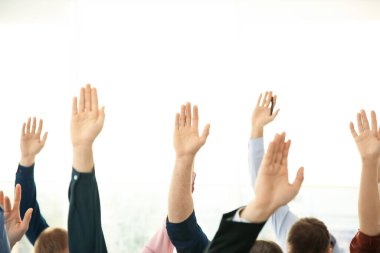 İş eğitiminde insanlar el kaldırarak ışık arkaplanı ve yakın plan hakkında sorular soruyorlar.