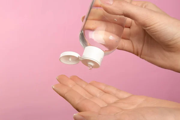 Mujer Aplicando Gel Antiséptico Sobre Fondo Rosa Primer Plano — Foto de Stock