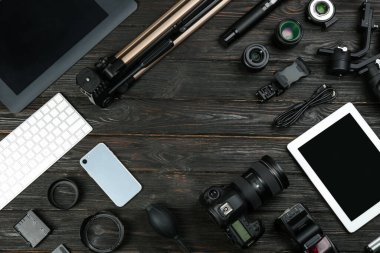 Siyah ahşap masa üzerinde kamera ve video üretim ekipmanları ile düz kompozisyon yatıyordu