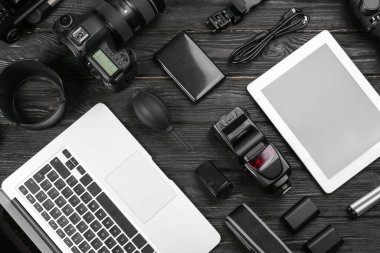 Siyah ahşap masa üzerinde kamera ve video üretim ekipmanları ile düz kompozisyon yatıyordu